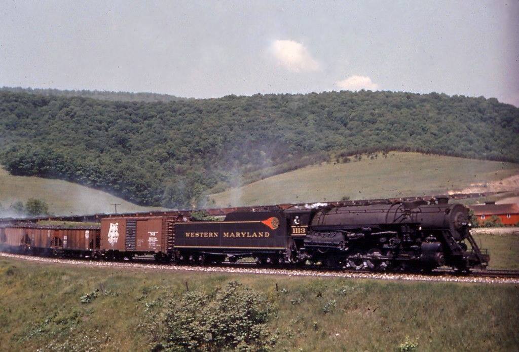 Western Maryland 2-10-0 1113 with brake shoes smoking on a coal train downgrade over Helmstetters Curve near Corriganville Maryland
