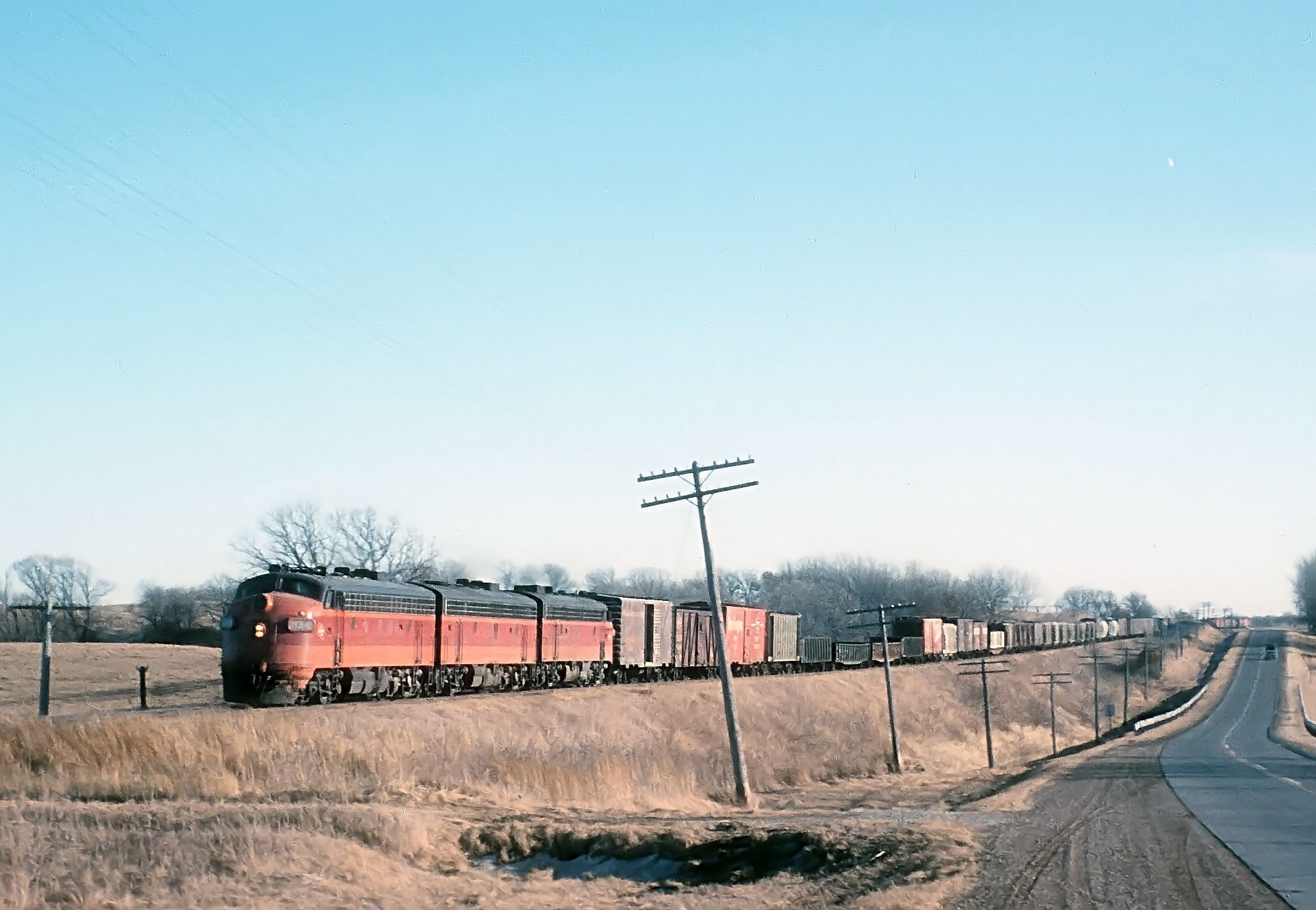 Milwaukee Road F7s leading train 63 along US 218 between Bixby and Owatonna, Minnesota, in February 1964