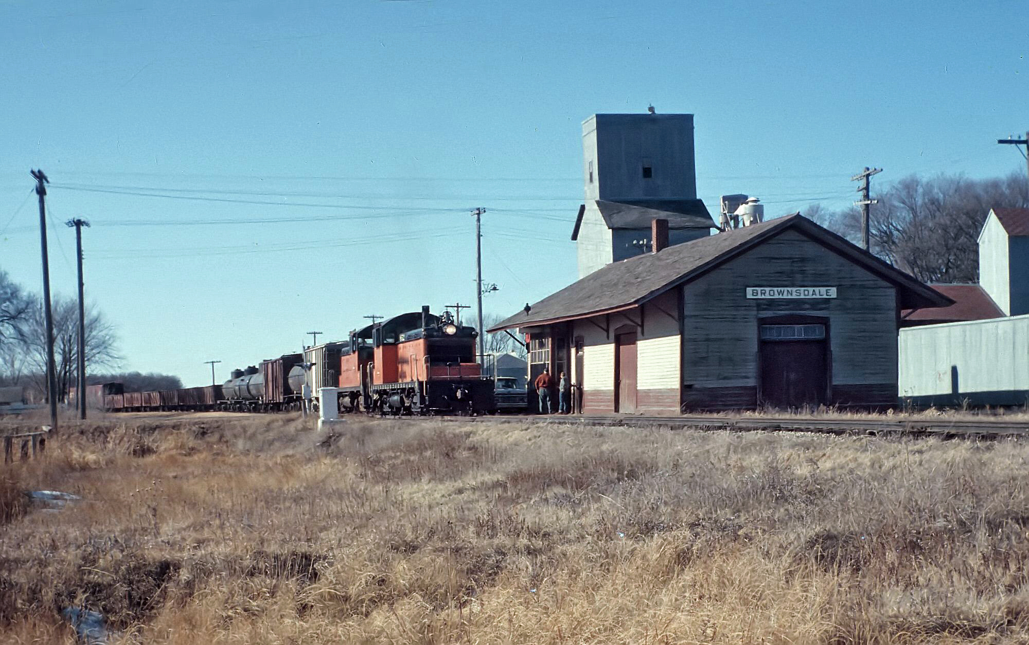 Milwaukee Road SW1 952 and 953 eastbound freight Brownsdale Minnesota February 1964
