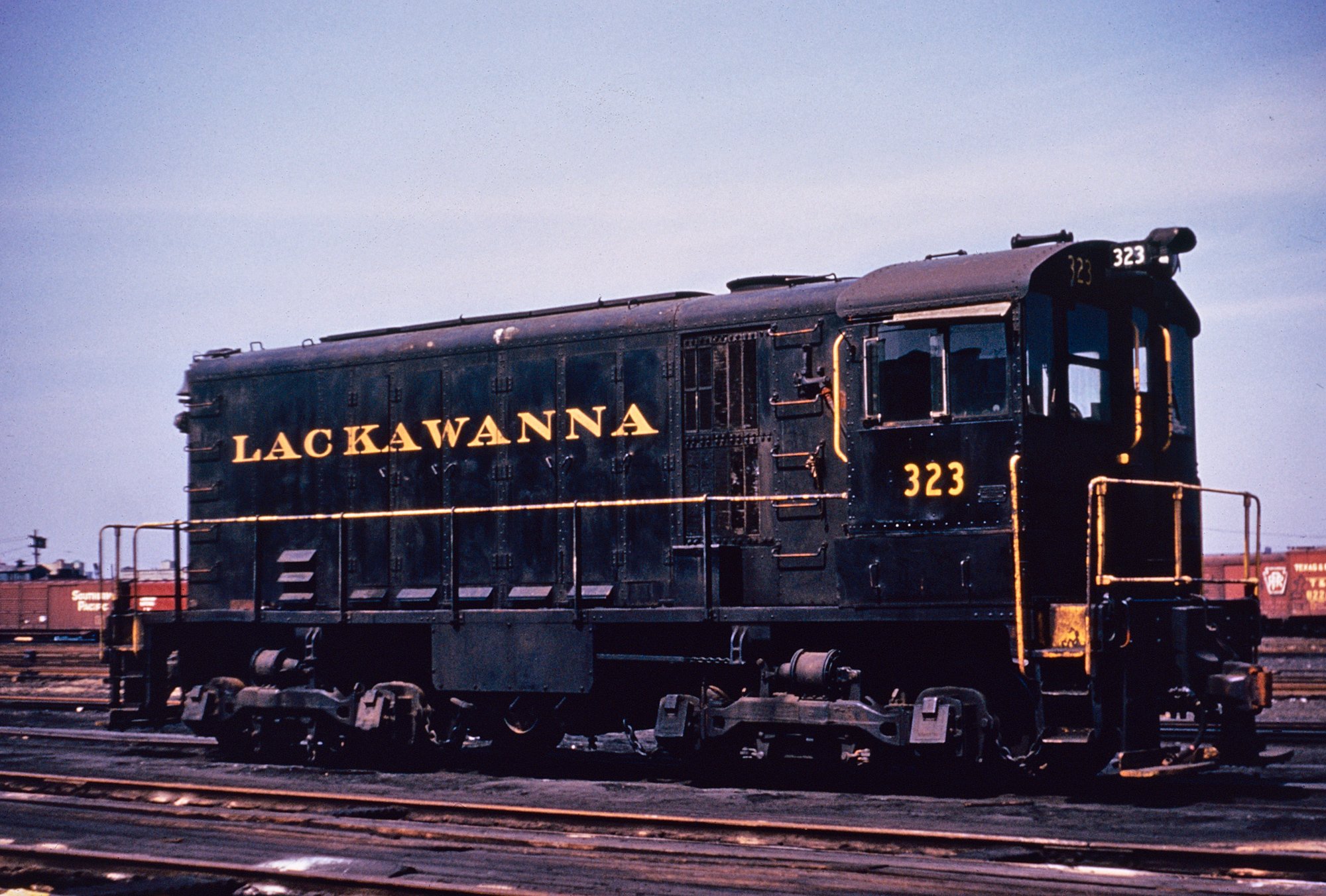 Erie Lackawanna HH600 #323, still in its Delaware, Lackawanna & Western scheme (built as #406), is seen here in Jersey City, New Jersey on June 23, 1964. American-Rails.com collection.