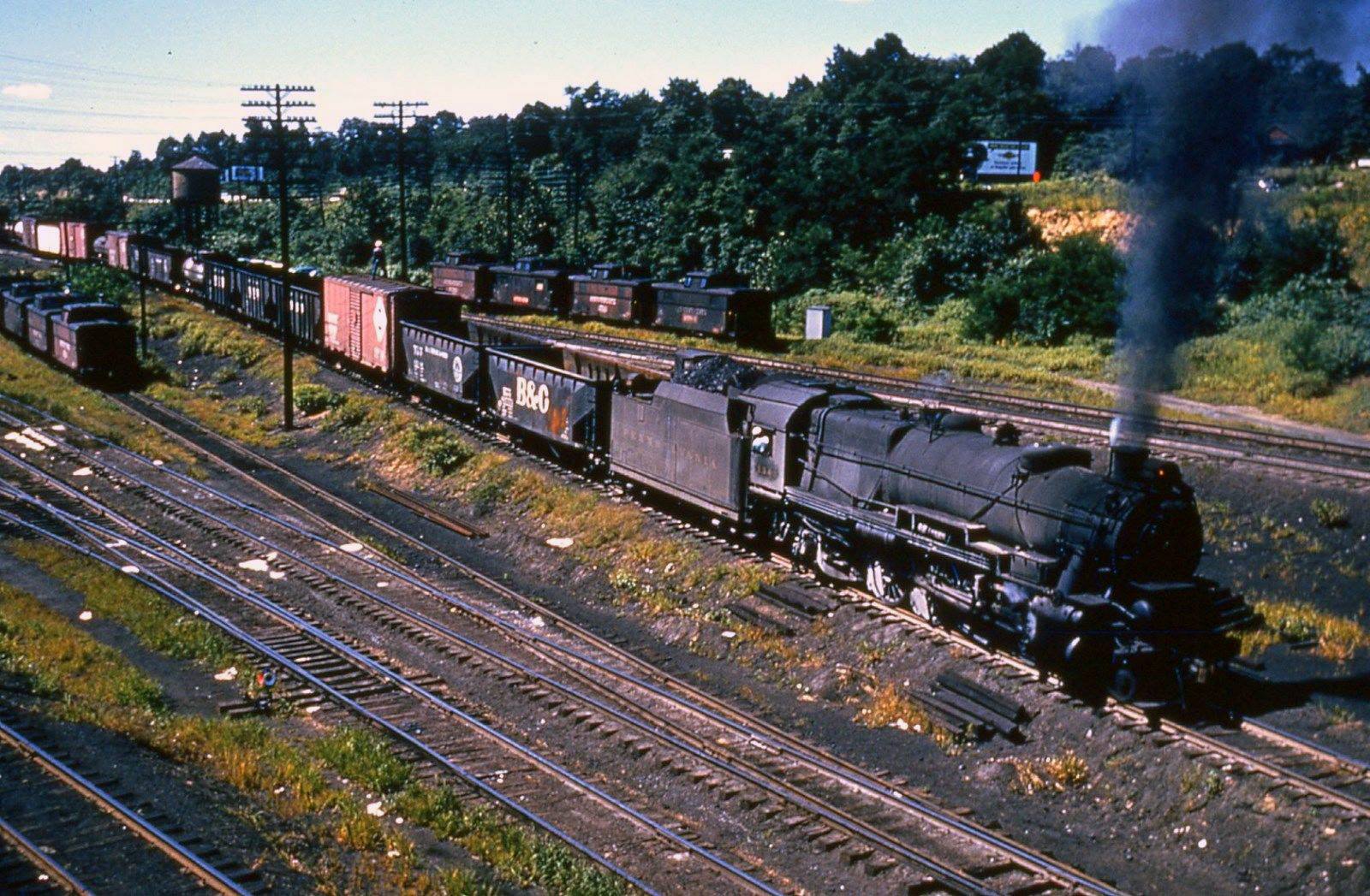 Pennsylvania Railroad 2-8-2 1343 with a Belpaire firebox at Enola circa 1956 and a brakeman riding a boxcar