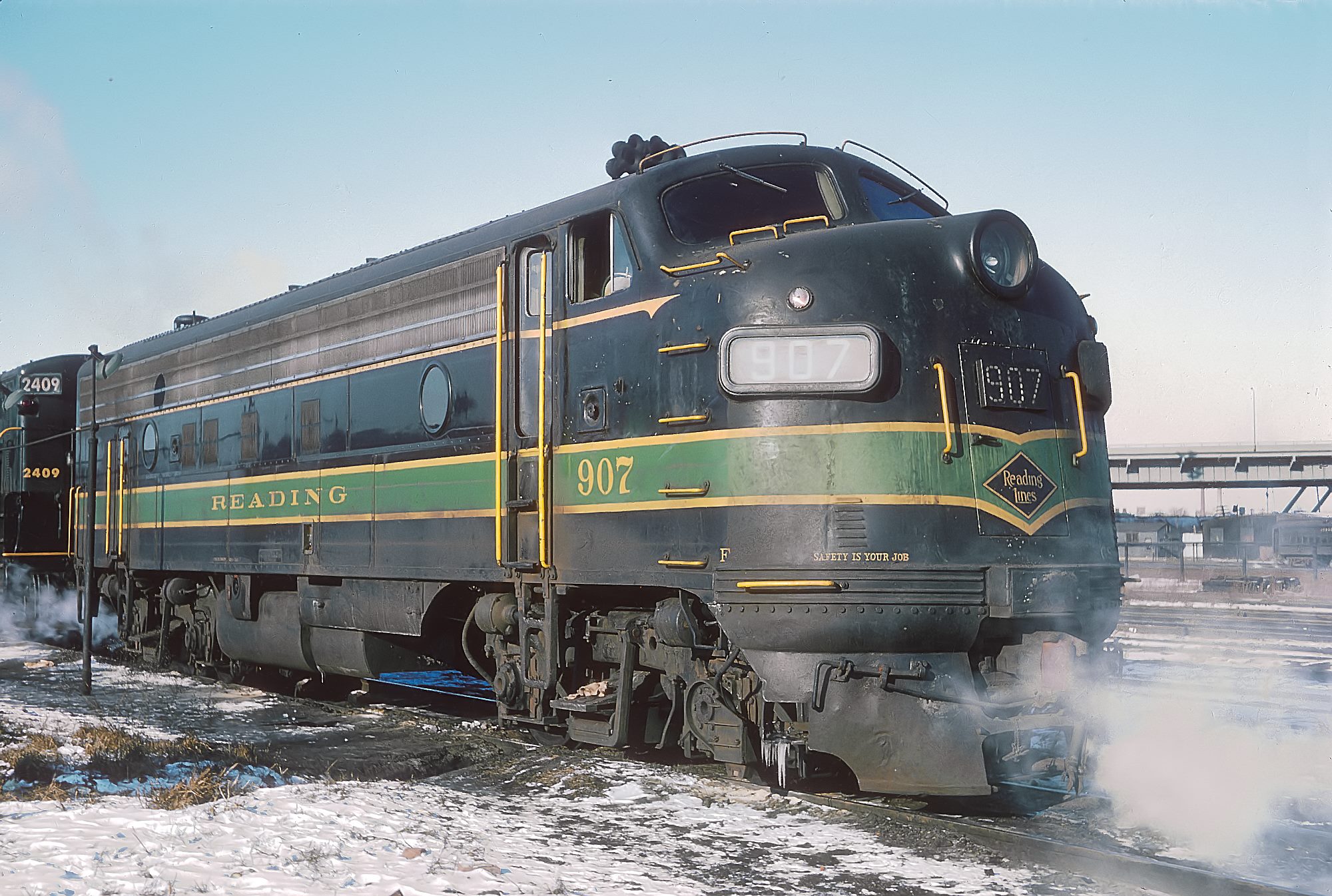 Reading FP7 907 at Jersey Central Communipaw Terminal in Jersey City in December 1963 with a CNJ Train Master behind
