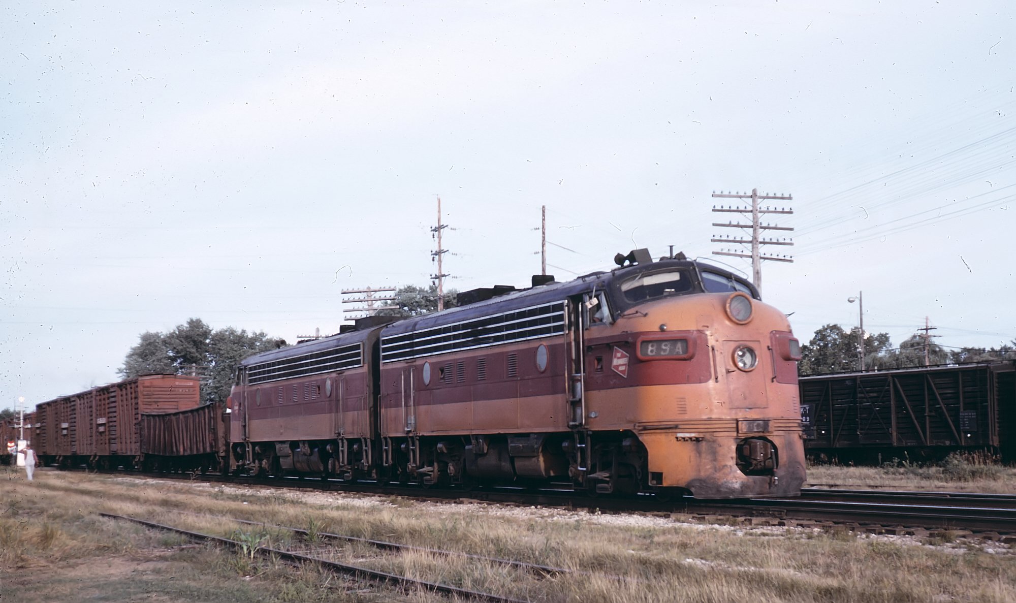 Milwaukee Road F7A 89A at Lanark Illinois August 17 1964 with livestock cars behind a gondola
