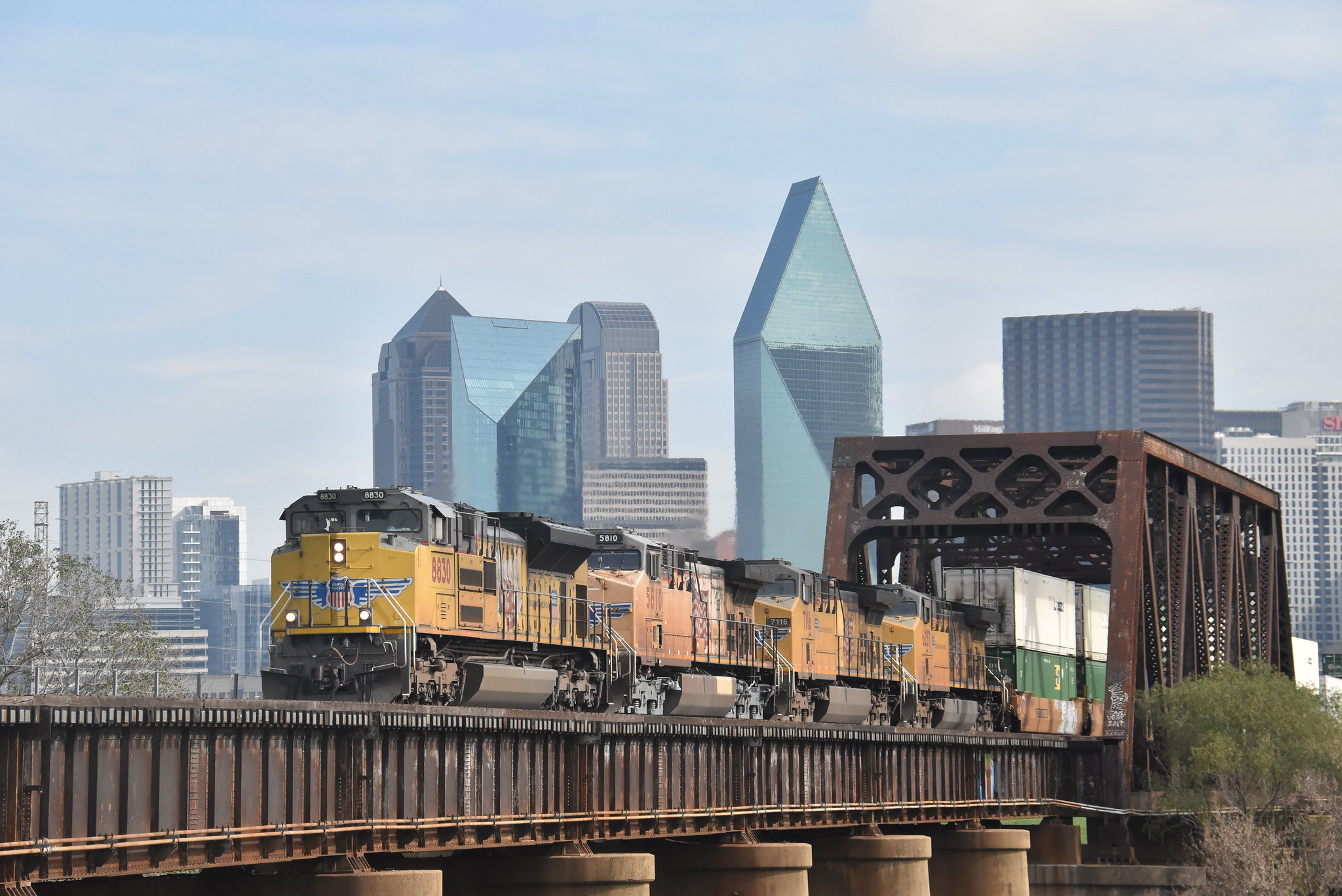 Union Pacific SD70ACe 8830 leading westbound freight across the Trinity River bridge with downtown Dallas Texas November 18 2023